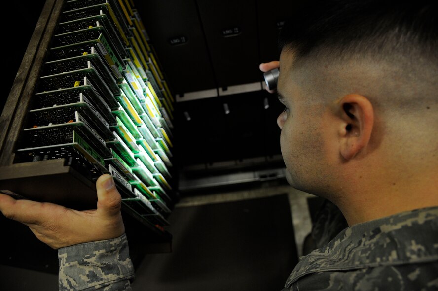 Senior Airman Jared Cooke, 2nd Communications Squadron cyber transport systems technician, searches for a line equipment number card on Barksdale Air Force Base, La., July 23, 2013. LENs serve as a telephone's memory, storing information such as voicemail and contact numbers. (U.S. Air Force photo/Airman 1st Class Andrew Moua)
