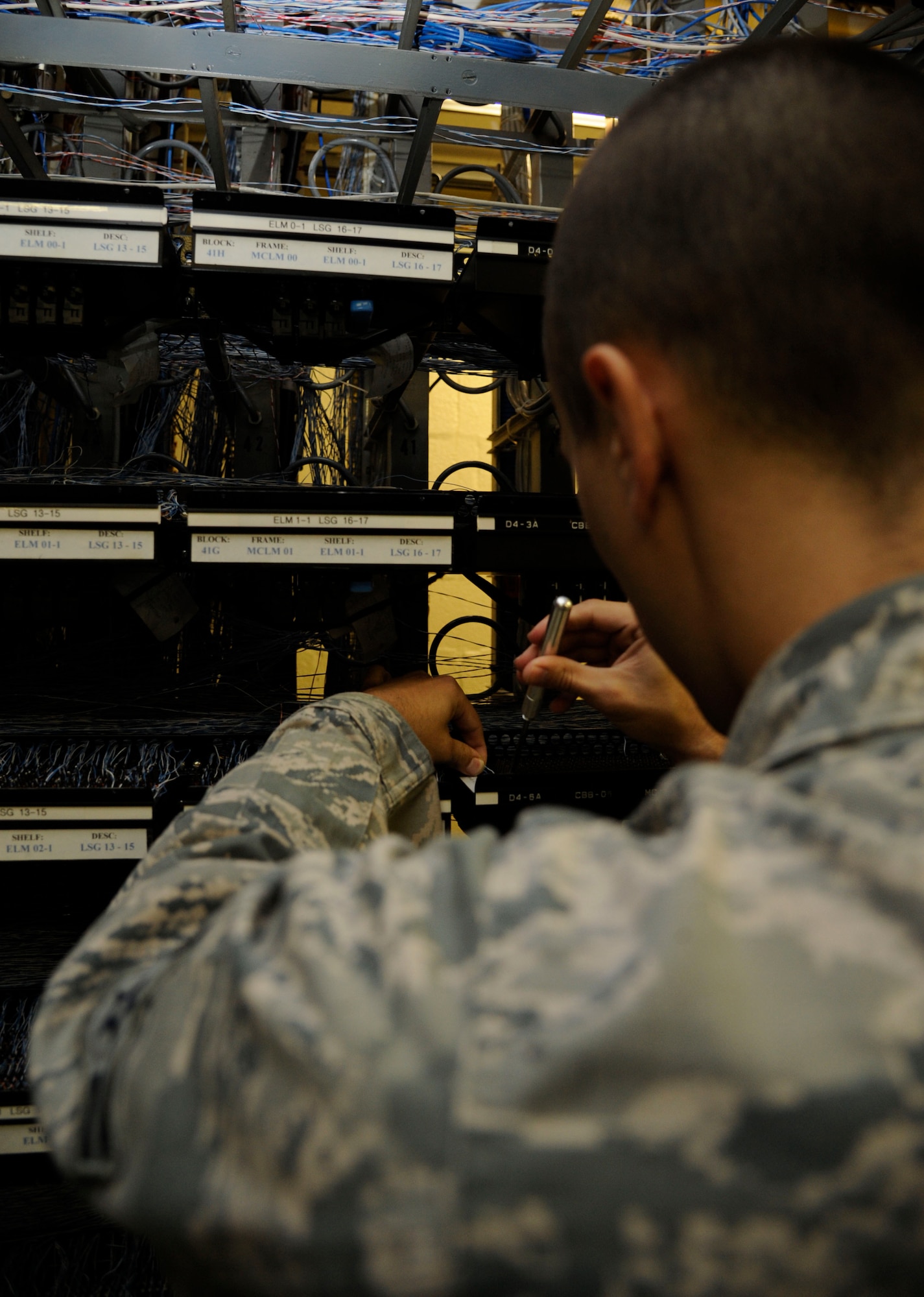 Airman 1st Class Zachary Sheridan, 2nd Communications Squadron cyber transport systems technician, wraps cabling around a cable block on Barksdale Air Force Base, La., July 23, 2013. The cabling is wrapped to a cable block when a new phone line is set up. (U.S. Air Force photo/Airman 1st Class Andrew Moua)