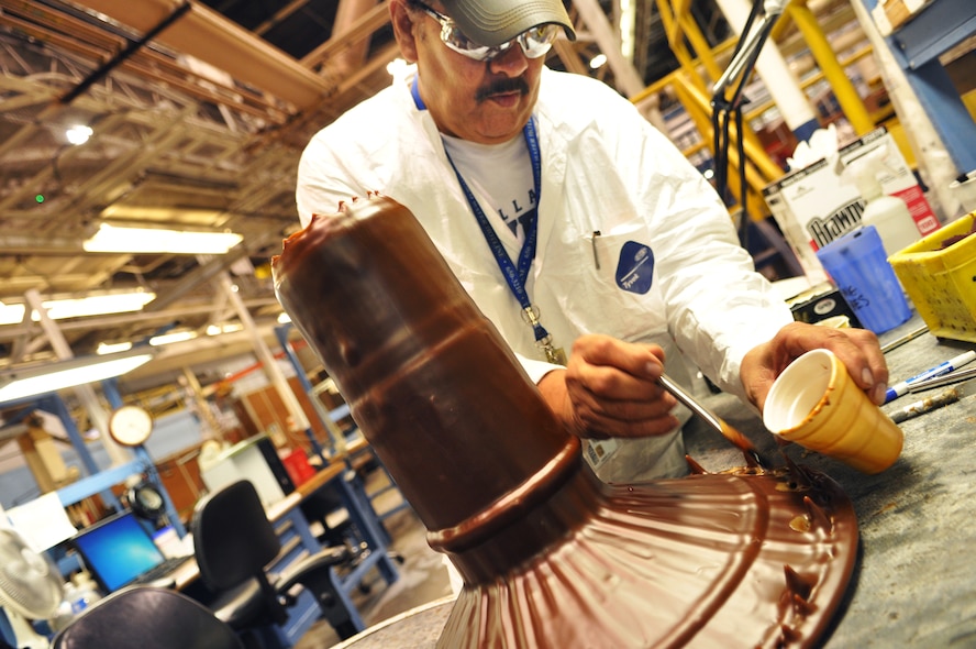 Electroplater Alfonso Tijerina applies small amounts of wax to an F100 drive shaft. Attention to detail is required because every piece of the engine part that is not going to be plated must be covered with protective wax. (Air Force photo by Micah Garbarino)