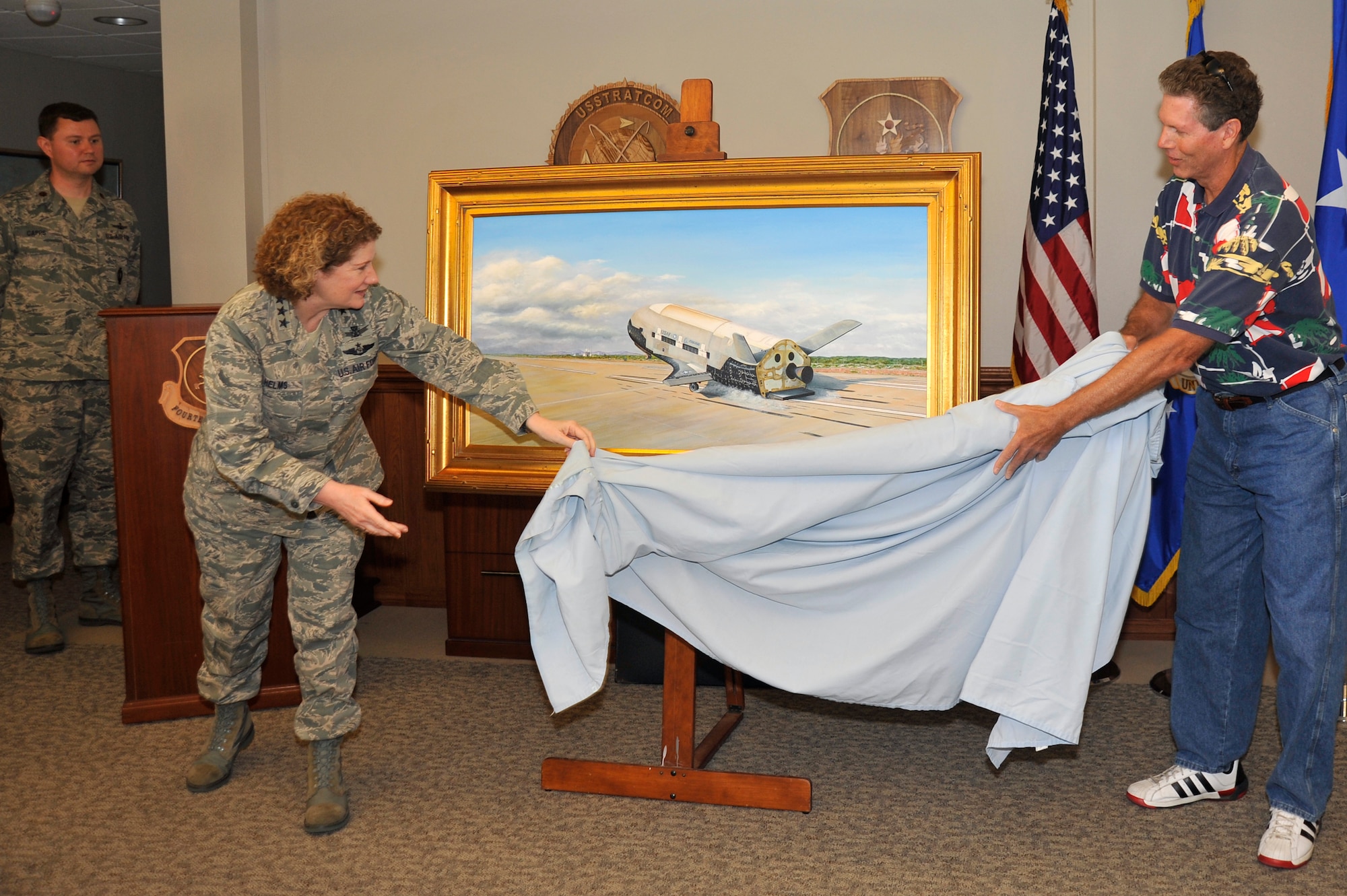 VANDENBERG AIR FORCE BASE, Calif. --  Lt. Gen. Susan Helms, commander of U.S. Strategic Command's Joint Functional Component Command for Space and 14th Air Force (Air Forces Strategic), and Mark Berger, artist, unveil Berger's original painting of the X-37B Orbital Test Vehicle during a ceremony at the 14th Air Force and 30th Space Wing Headquarters building here June 17, 2013. Berger presented his artwork to the 14th AF and 30th SW on behalf of the Air Force Rapid Capabilities Office. The X-37B is the Air Force's first unmanned re-entry spacecraft. The spacecraft has landed at VAFB following two separate, successful missions on Dec. 3, 2010, and June 16, 2012. (U.S. Air Force photo/Michael Peterson)