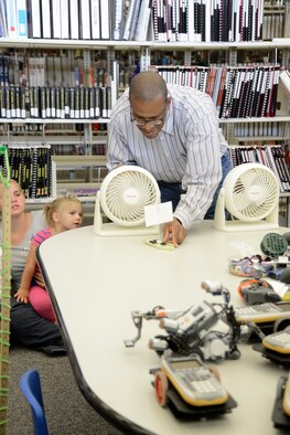Mickey Bowen, 412th Test Wing STEM outreach director, uses a paper boat powered by a fan to demonstrate the concepts of force and weight. (U.S. Air Force photo by Rebecca Amber) 
