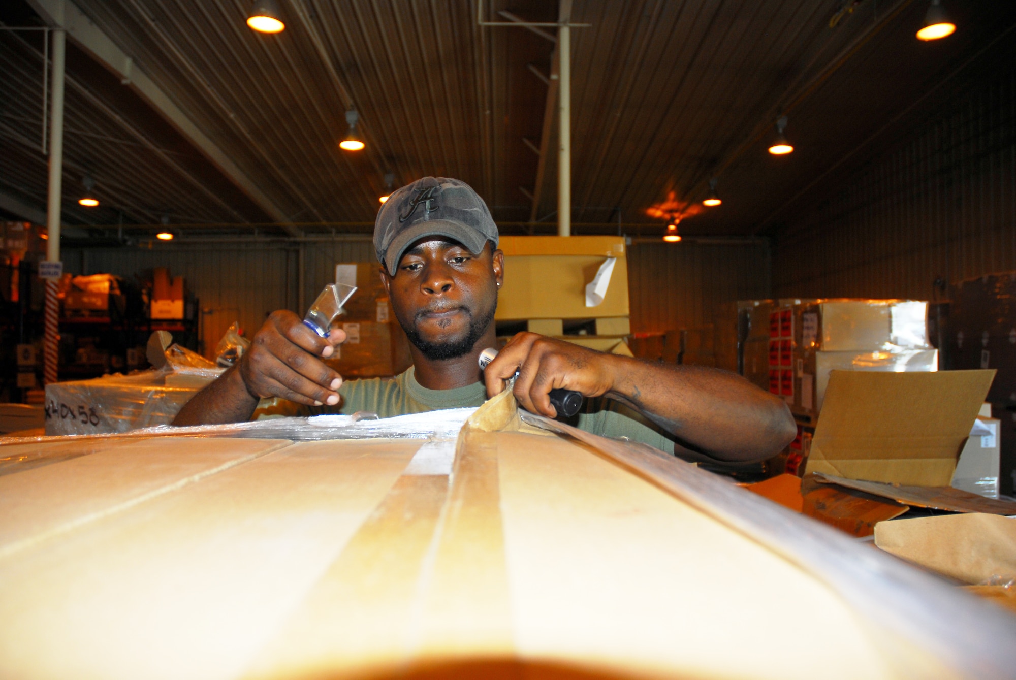 Eric Woods, a Defense Logistics Agency Disposition Services material identifier examiner, examines incoming items shipped to Robins. The installation’s property turn-in averages about 140,000 line items each year. (U.S. Air Force photo by Ed Aspera)
