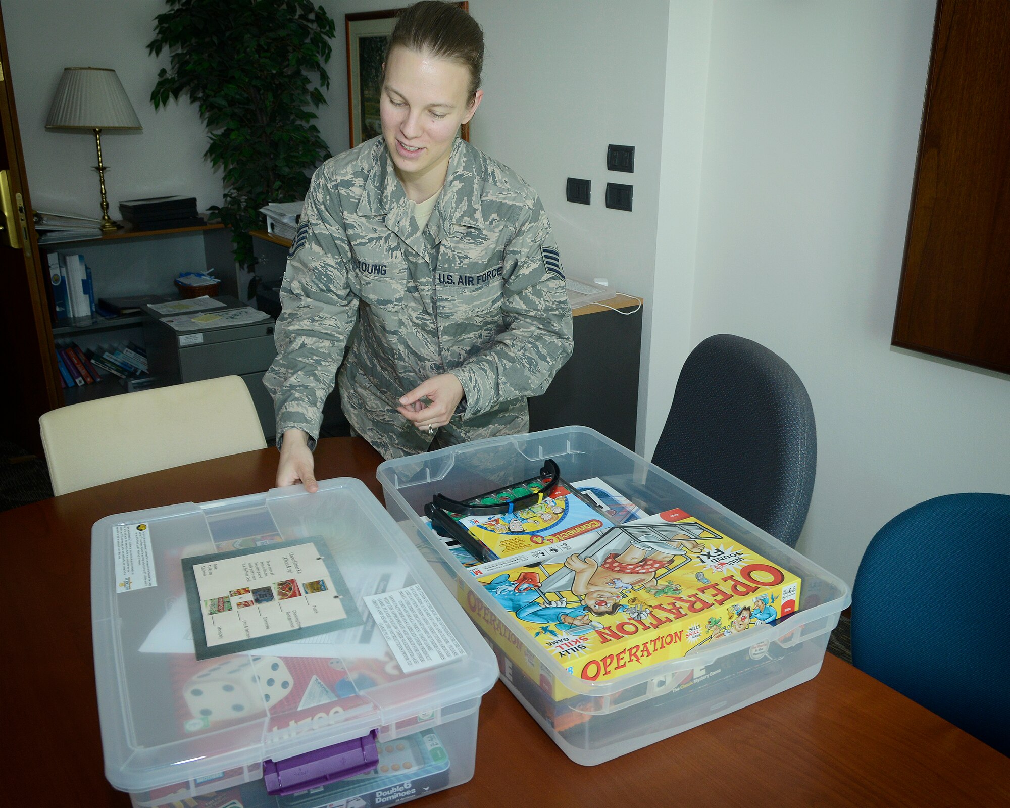 Staff Sgt. Janet Young, 31st Force Support Squadron lodging quality assurance and training manager, opens a game kit available for rent at the Mountain View Lodge July 22, 2013, on Aviano Air Base, Italy. Filled with various board games and puzzles, each kit costs $3 a night or $15 a week and are separated into three categories: toddler kit, classic-games kit and school-age kit. (U.S Air Force photo/ Senior Airman Jessica Hines)