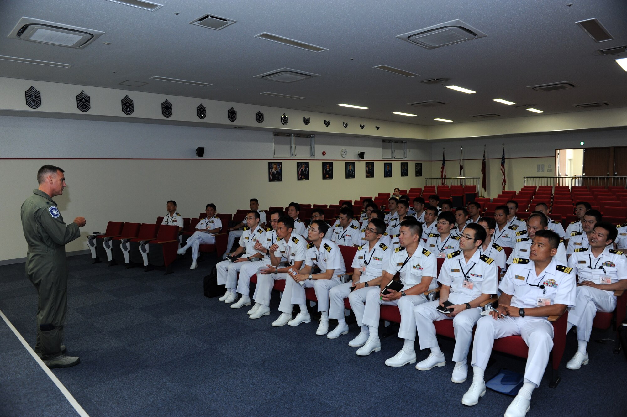 U.S. Air Force Lt. Col. Paul Johnson, 18th Operations Group vice commander, answers questions from Japan Maritime Self-Defense Force senior officers at the Erwin Professional Military Education Center on Kadena Air Base, Japan, July 23, 2013. The JMSDF Staff College provides field trips to students in the Command and Staff Course. As part of the 2013 academic curriculum, approximately 39 instructors and students from the college visited Kadena in order to help the students broaden their views on maritime defense strategies and make proper decisions on military issues. (U.S. Air Force photo by Airman 1st Class Hailey R. Davis/Released)