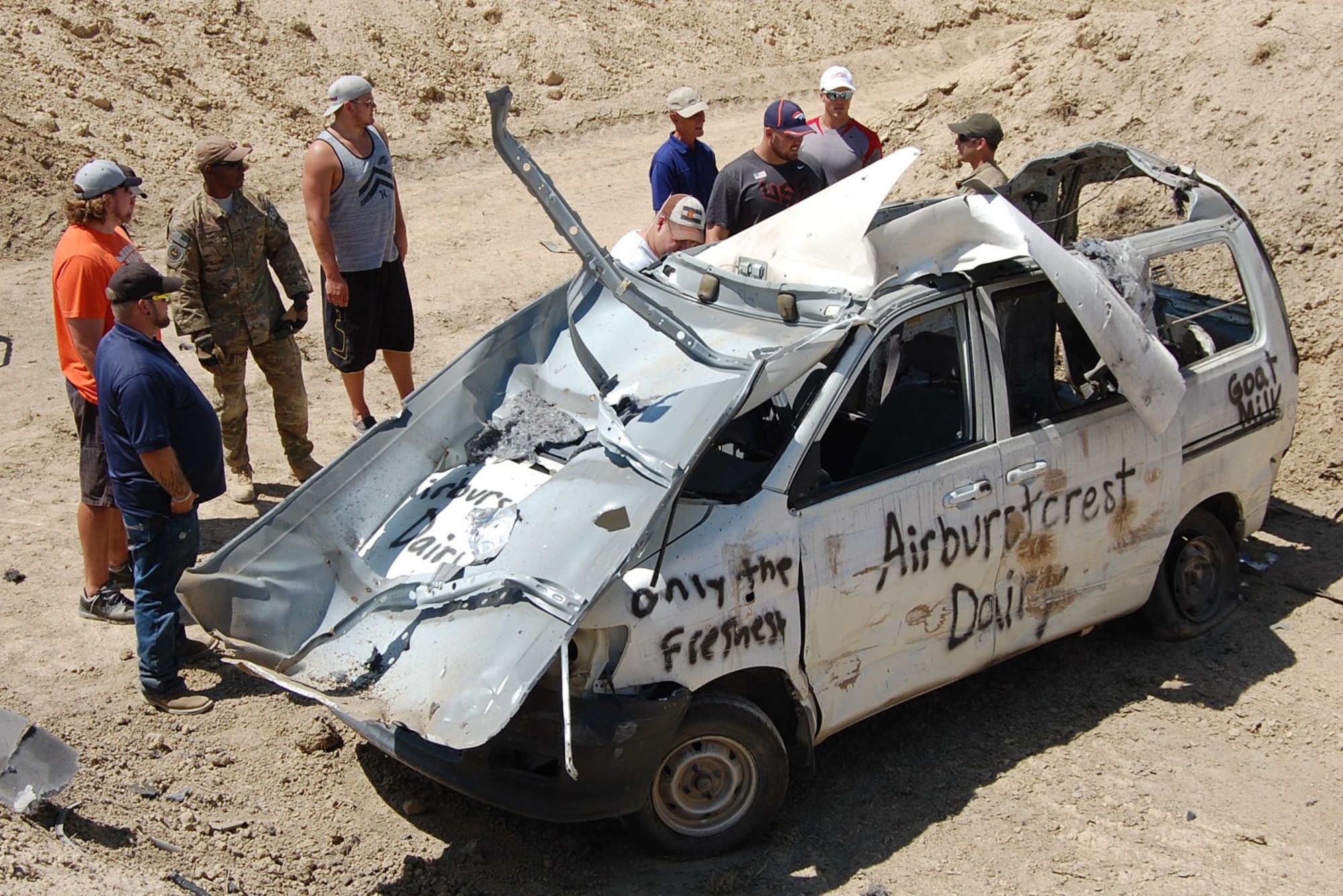 Visitors assess the damage done to a vehicle by a hydraulic explosive device during the EOD Demo Day July 12, 2013 at Airburst Range, Fort Carson, Colo. (U.S. Air National Guard photo by Capt. Kinder Blacke)