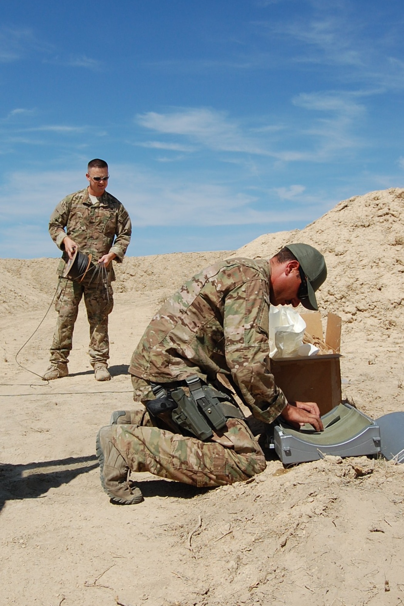 Colorado Air National Guard Airman 1st Class Darrell Linkus, 140th Explosive Ordnance Disposal Flight, assembles a hydraulic explosive tool, or “Bootbanger”, that will be used to blow up a vehicle during the EOD Demo Day July 12, 2013 at Airburst Range, Fort Carson, Colo., while Tech. Sgt. Andrew LeBeau, supervises his training. (U.S. Air National Guard photo by Capt. Kinder Blacke)