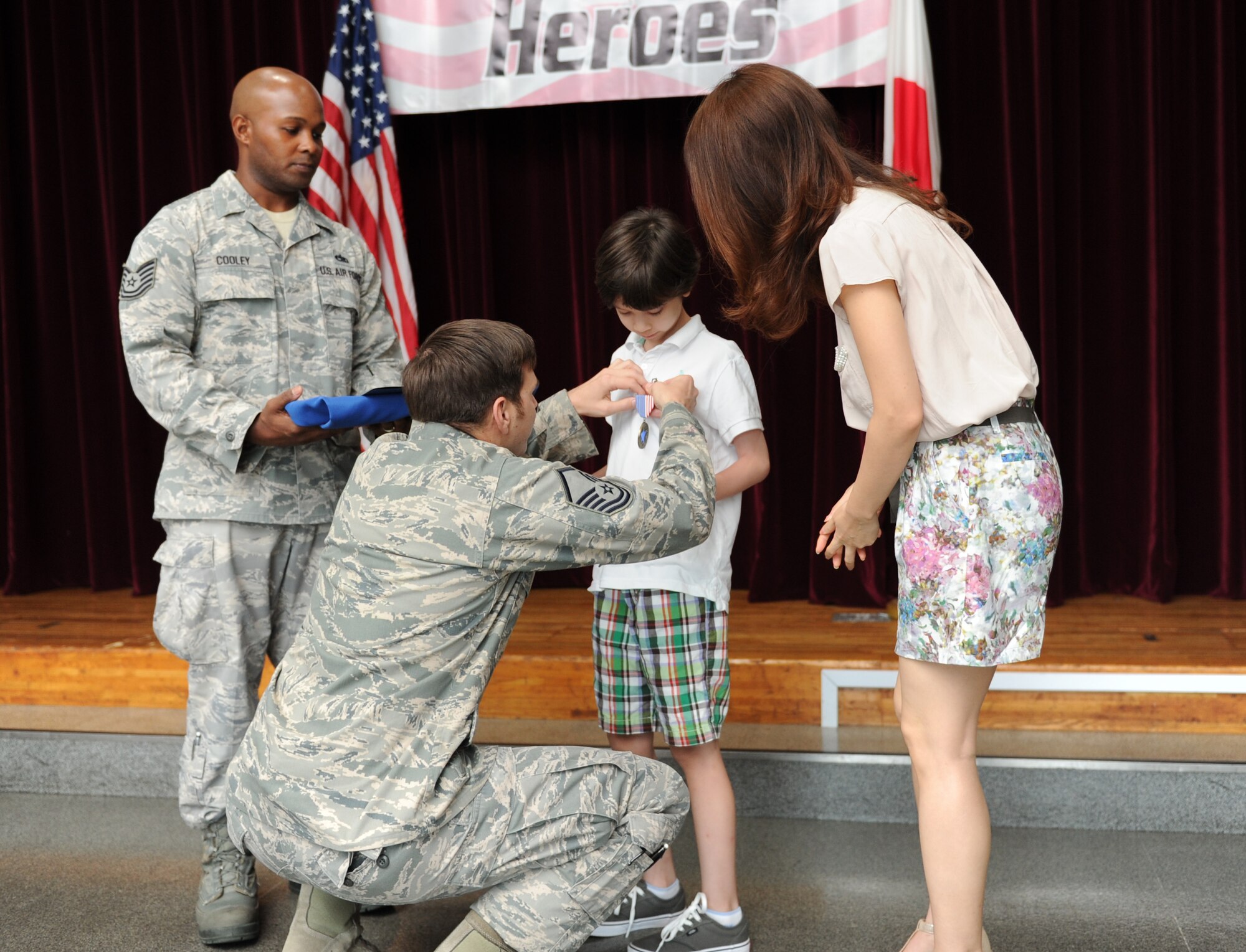 YOKOTA AIR BASE, Japan -- Master Sgt. Brent Paul, 374th Security Forces Squadron, pins a Blue Star medal on his son, Jason Paul, during a Home Front Hero award ceremony at Yokota Air Base, Japan, July 22, 2013. The quarterly award honors the contributions of children whose parents are deployed or on extended duty assignments and is based on nominations by their parents. (U.S. Air Force photo by Senior Airman Andrea Salazar)