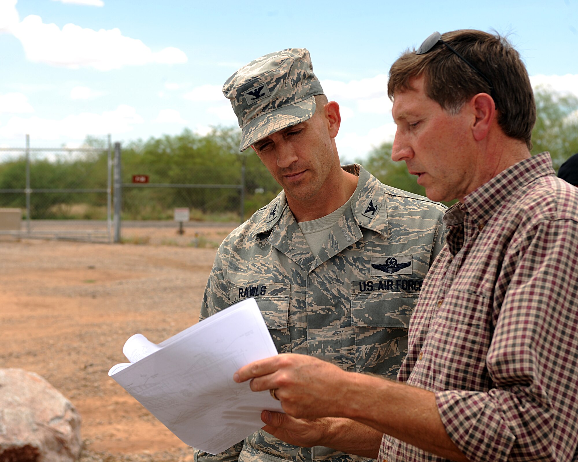 U.S. Air Force Col. Michael Rawls, 355th Fighter Wing vice commander, and James Johnsen, 355th Civil Engineer Squadron project manager, look over plans for Gate 29B at Davis-Monthan Air Force Base, Ariz., July 18, 2013. Gate 29B will have a limited opening on July 29. (U.S. Air Force photo by Senior Airman Timothy Moore/Released)