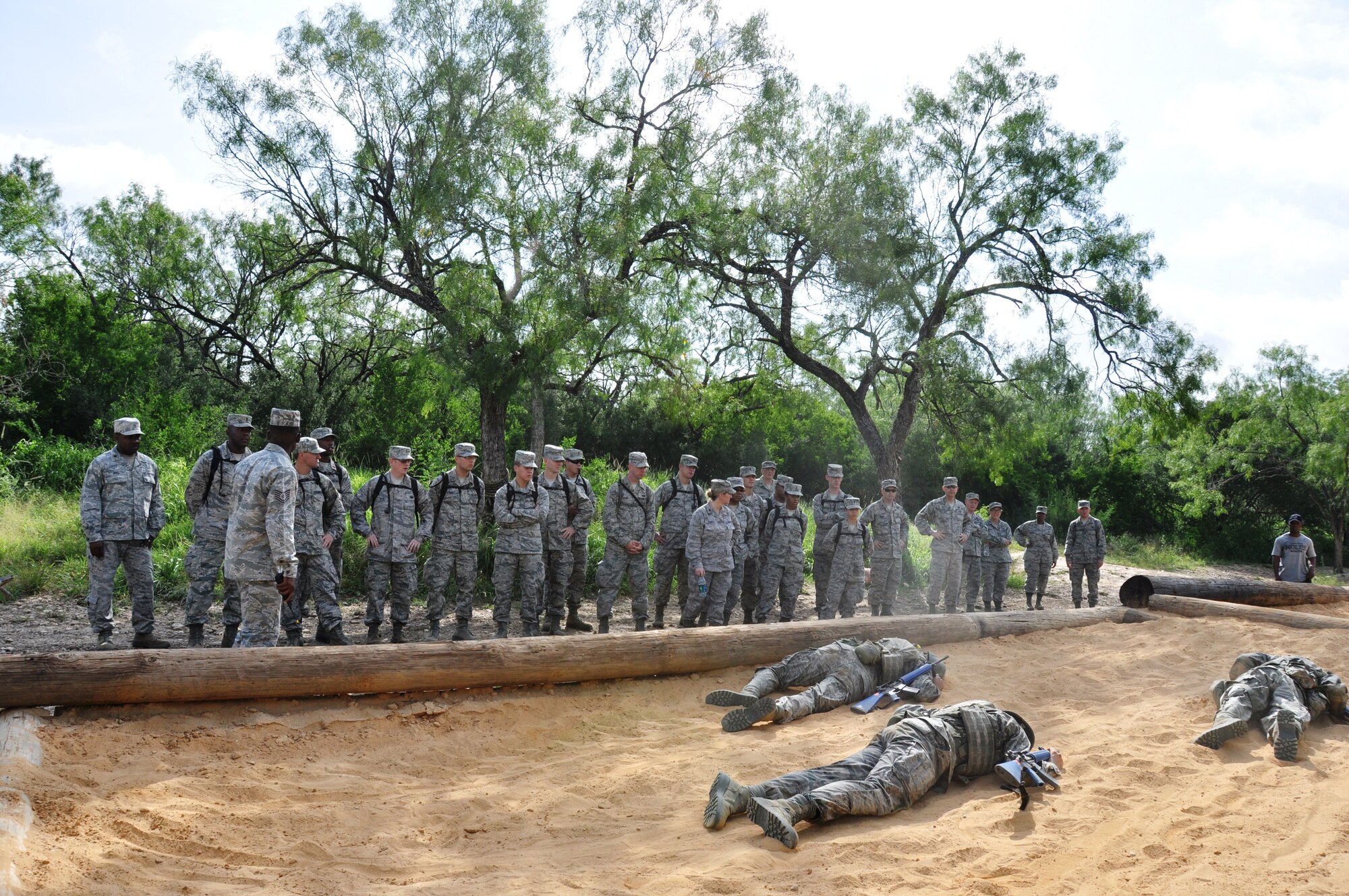 Chaplain candidates observe basic trainees during a 50-yard low crawl up a hill through deep sand at the Basic Expeditionary Airman Skills Training. With encouragement from the candidates and Wingman trainee, a struggling trainee finished the course, then ran an additional 50 yards over rocky terrain. (Air Force photo by Tech Sgt. Carlos Trevino)