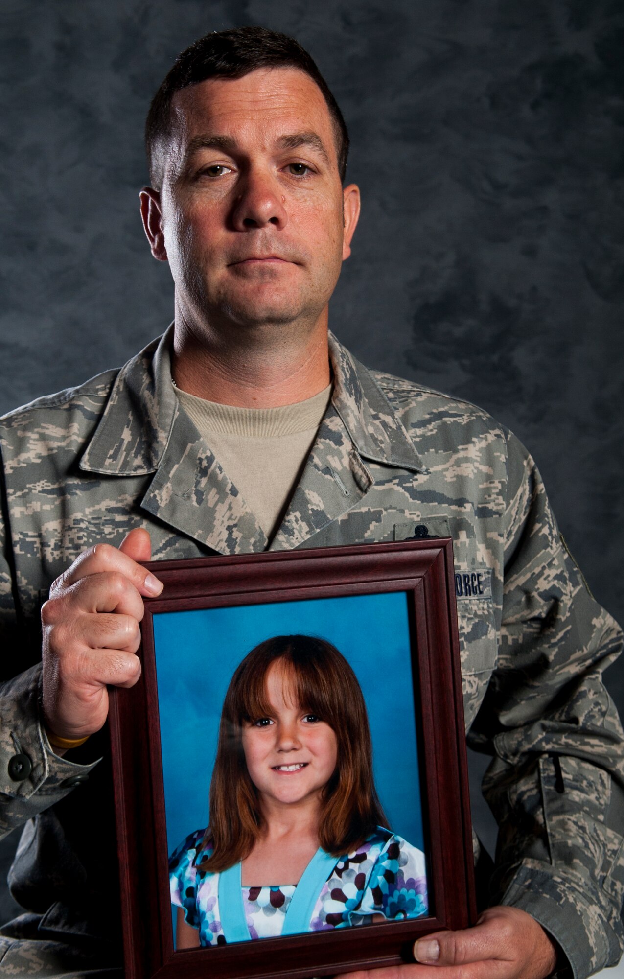 U.S. Air Force Master Sgt. Benjamin Pitts, 23d Wing Plans, Programs and Inspections superintendant of exercise and wing evaluations, holds a picture of late daughter, Elizabeth, July 22, 2013, at Moody Air Force Base, Ga. While battling cancer, Elizabeth donated teddy bears to children in hospitals. (U.S. Air Force photo by Airman 1st Class Sandra Marrero/Released)
