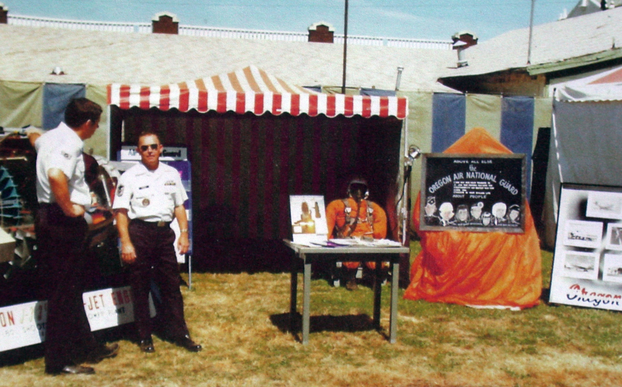 SMSgt Gene Thomas (right), OreANG Recruiter, speaks with an unidentified airman at the OreANG Recruiting stand at the State Fair in Salem, Oregon, in the summer of 1974.