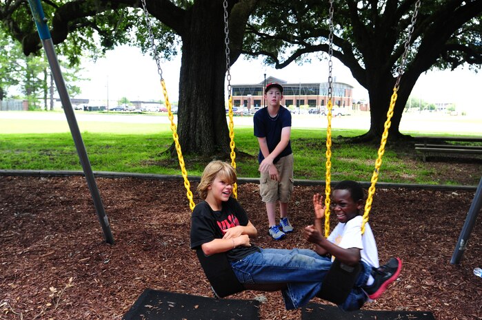 Children from the Eagle Harbor Boys Ranch enjoy the swings during a visit July 22, 2013, at Joint Base Charleston – Air Base, S.C. The boys watched a K-9 demonstration and were able to examine the 628th Security Forces Squadron patrol cars. The 628th Civil Engineer Squadron Fire Department also briefed the children about their jobs as firefighters and gave them a tour of the fire station. (U.S. Air Force photo/ Staff Sgt. David Collins )
