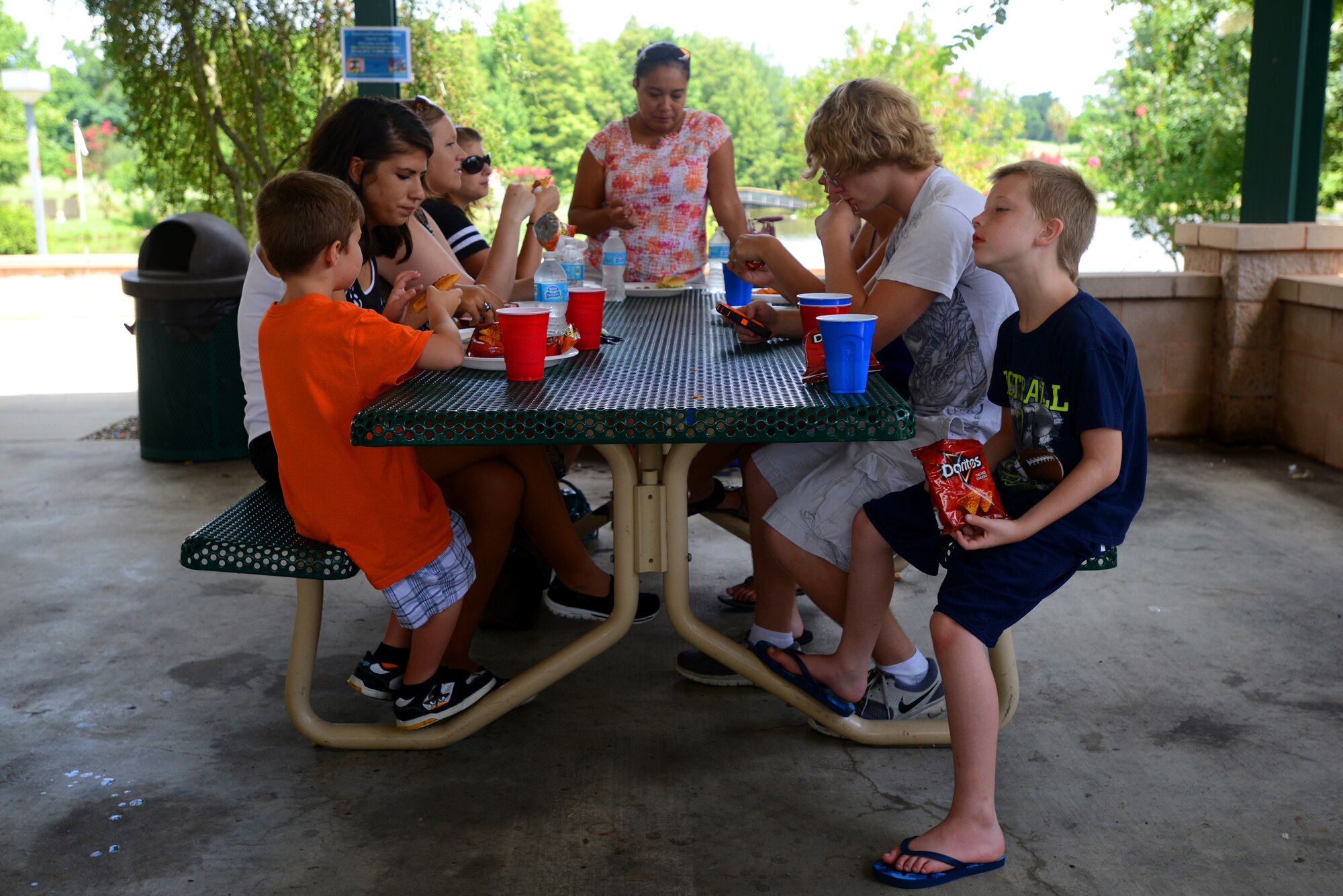 Participants of the Hearts Apart event sit and eat at Memorial Lake Pavilion, Shaw Air Force Base, S.C., July 20 2013.  Hearts Apart events give the families of deployed or remote tour Airmen a chance to have fun, relax, and network with other families.