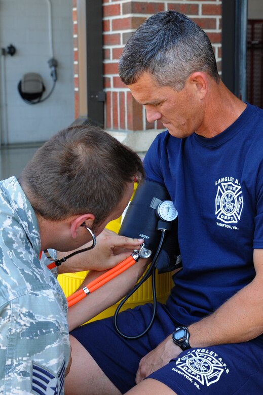 U.S. Air Force Staff Sgt. Adam Washburn, 633rd Civil Engineer Squadron firefighter, checks the blood pressure of Chief Master Sgt. Richard Parsons, command chief of Air Combat Command, prior to performing the firefighters’ challenge at Langley Air Force Base, Va., July 17, 2013. The firefighters challenge is a fitness requirement for all firefighters and is physically demanding. (U.S. Air Force photo by Airman 1st Class Victoria H. Taylor/Released)