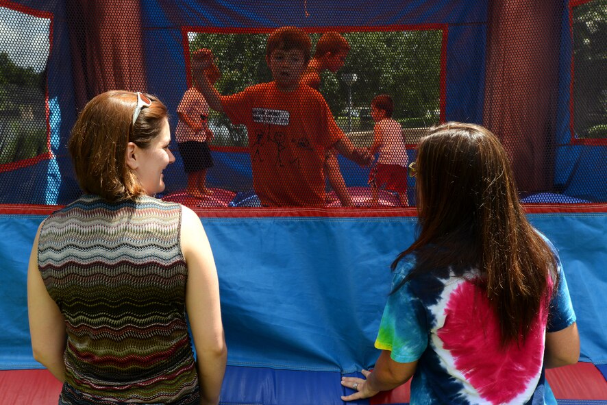 Ann Mussio (left) and Amber Watkins talk in front of a bouncy castle during a Hearts Apart event at Memorial Lake Pavilion, Shaw Air Force Base, S.C., July 20 2013.  Hearts Apart give the families of deployed or remote tour Airmen a chance to have fun, relax, and network with other families.