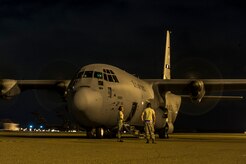 Members of the crew of a C-130J-30 from Dyess Air Force Base, Texas, wait outside of the aircraft before takeoff after an early morning cargo load July 23, 2013, at Joint Base Charleston - Air Base, S.C. The C-130J-30 was loaded with rations and supplies bound for Bogota. The C-130J-30 is a stretch version of the C-130J, a proven, highly reliable and affordable airlifter. The C-130J-30 adds 15 feet to the fuselage, increasing usable space in the cargo compartment. (U.S. Air Force photo/Senior Airman George Goslin) 
