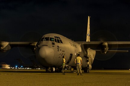 Members of the crew of a C-130J-30 from Dyess Air Force Base, Texas, wait outside of the aircraft before takeoff after an early morning cargo load July 23, 2013, at Joint Base Charleston - Air Base, S.C. The C-130J-30 was loaded with rations and supplies bound for Bogota. The C-130J-30 is a stretch version of the C-130J, a proven, highly reliable and affordable airlifter. The C-130J-30 adds 15 feet to the fuselage, increasing usable space in the cargo compartment. (U.S. Air Force photo/ Senior Airman George Goslin)