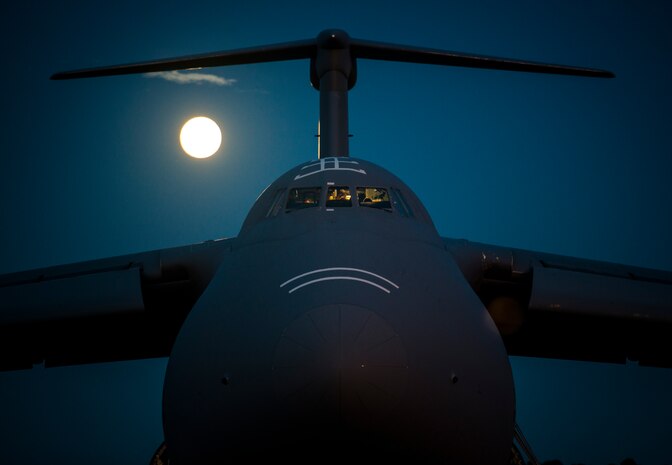 The moon rises as West Virginia Air National Guard aircrew members with the 167th Airlift Wing out of Martinsburg, W. Va., perform post flight checks inside the cockpit of a C-5 Galaxy, July 22, 2013, at Joint Base Charleston – Air Base, S.C. Airmen from the 167th AW loaded cargo onto the C-5 to be used to support Operation Enduring Freedom. The C-5 is one of the largest aircraft in the world and the largest airlifter in the Air Force inventory. (U.S. Air Force photo/ Senior Airman Dennis Sloan)