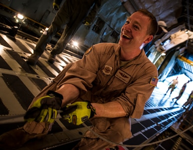 Tech. Sgt. David Bowers, West Virginia Air National Guard member, 167th Maintenance Squadron C-5 Galaxy load master from Martinsburg, W. Va., feeds a metal tension cord into place before using it to move a load of cargo on a C-5 July 22, 2013, at Joint Base Charleston – Air Base, S.C. The cargo is being used to assist operation Enduring Freedom. The C-5 is one of the largest aircraft in the world and the largest airlifter in the Air Force inventory. (U.S. Air Force photo/ Senior Airman Dennis Sloan)