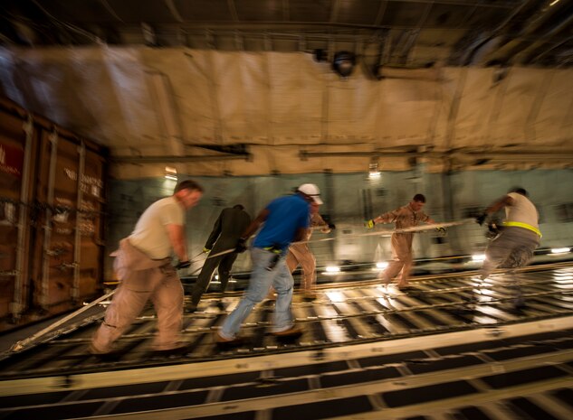 West Virginia Air National Guard members from the 167th Airlift Wing, Martinsburg, W. Va., work with Airmen and civilians from the 437th Aerial Port Squadron, to load cargo on to a C-5 Galaxy July 22, 2013, at Joint Base Charleston, S.C. The cargo is being used to assist operation Enduring Freedom. The C-5 is one of the largest aircraft in the world and the largest airlifter in the Air Force inventory. (U.S. Air Force photo/ Senior Airman Dennis Sloan)