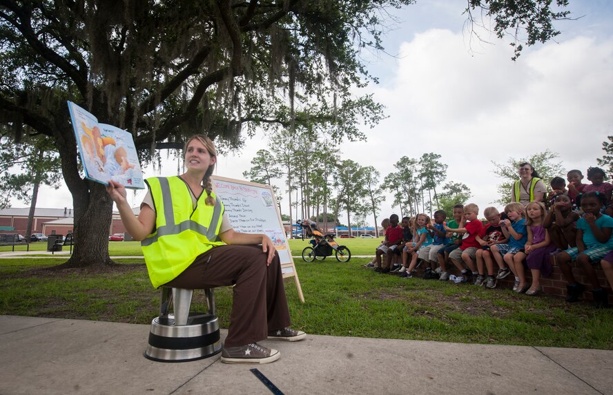 Lacey Hanna, Child Development Center caregiver, reads to children during storytime at Moody Air Force Base, Ga., June 11, 2013. The Summer Reading Program encourages older children and teenagers to check out their own books, while younger children can take part in the interactive storytime. (U.S. Air Force photo by Senior Airman Jarrod Grammel/Released)
