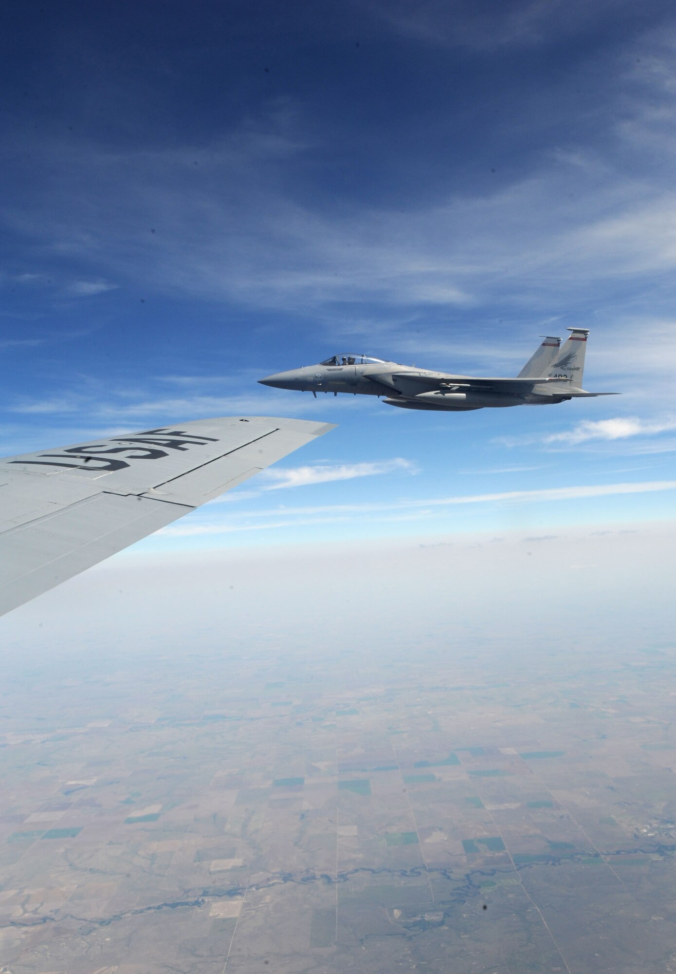 An F-15 Eagle from the 142nd Fighter Wing, Oregon Air National Guard, Portland, Ore., flies alongside a KC-135 Stratotanker assigned to McConnell Air Force Base, Kan., July 23, 2013. The F-15 was one of eight to receive fuel from three McConnell tankers during the training mission over northeast Kansas. (U.S. Air Force photo/Senior Airman Laura L. Valentine)