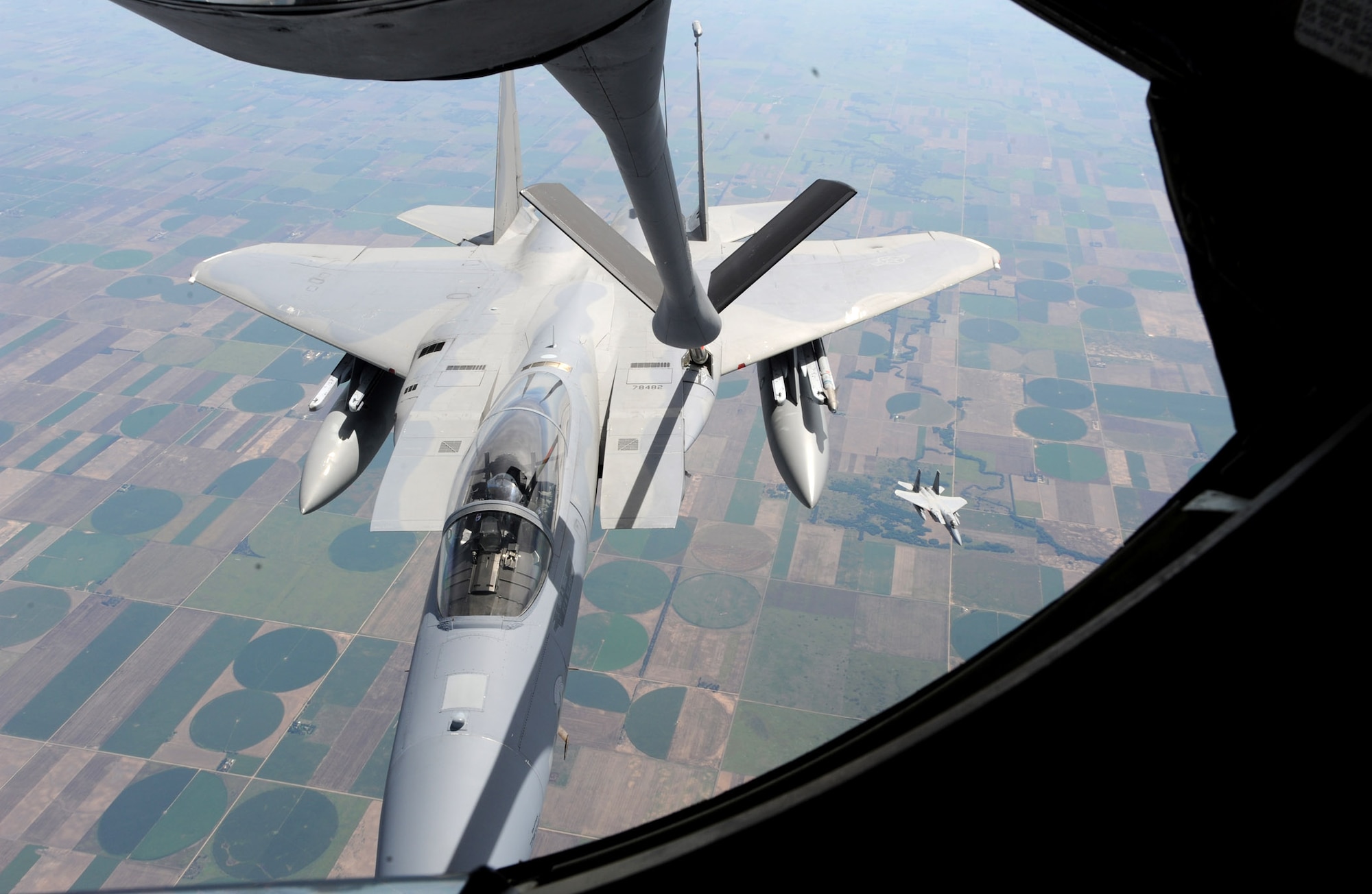 An F-15 Eagle from the 142nd Fighter Wing, Oregon Air National Guard, Portland, Ore., receives fuel from a KC-135 Stratotanker assigned to McConnell Air Force Base, Kan., while a second F-15 moves to the left wing of the Stratotanker July 23, 2013. Three Stratotankers refueled eight F-15s during the training mission over northeast Kansas. (U.S. Air Force photo/Senior Airman Laura L. Valentine)