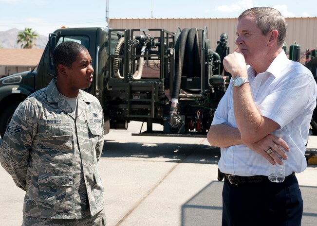 Airman 1st Class David Brewer, 99th Logistics Readiness Squadron fuels specialist, briefs Retired Chief Master Sgt. Eric Benken, the 12th Chief Master Sgt. of the Air Force July 19, 2013, during an orientation visit to Nellis Air Force Base, Nev. (U.S. Air Force photo by Staff Sgt. Michael Charles)