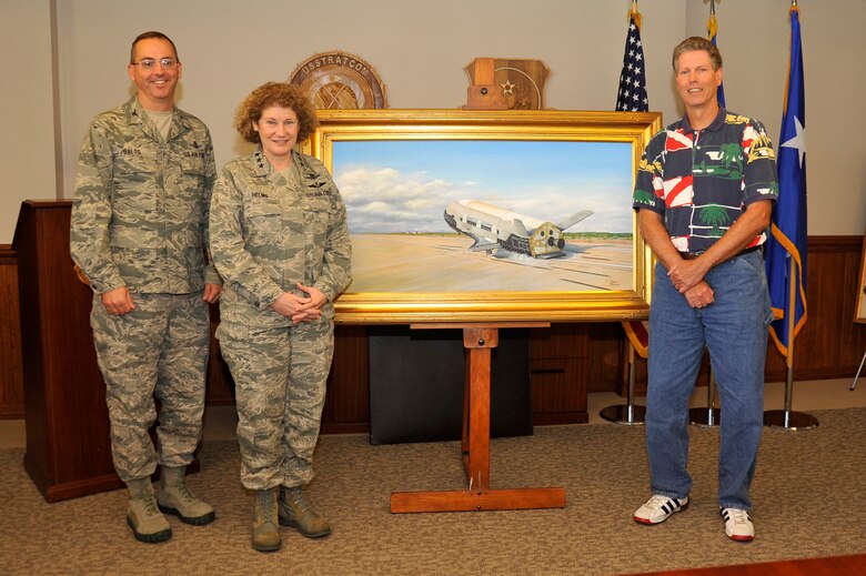 VANDENBERG AIR FORCE BASE, Calif. --  Col. Keith Balts, 30th Space Wing commander, Lt. Gen. Susan Helms, commander of U.S. Strategic Command's Joint Functional Component Command for Space and 14th Air Force (Air Forces Strategic), and Mark Berger, artist, stand with Berger's original painting of the X-37B Orbital Test Vehicle during a ceremony here June 17, 2013. Berger presented his artwork to the 14th AF and 30th SW on behalf of the Air Force Rapid Capabilities Office. The X-37B is the Air Force's first unmanned re-entry spacecraft. The spacecraft has landed at VAFB following two separate, successful missions on Dec. 3, 2010, and June 16, 2012. (U.S. Air Force photo/Michael Peterson)
