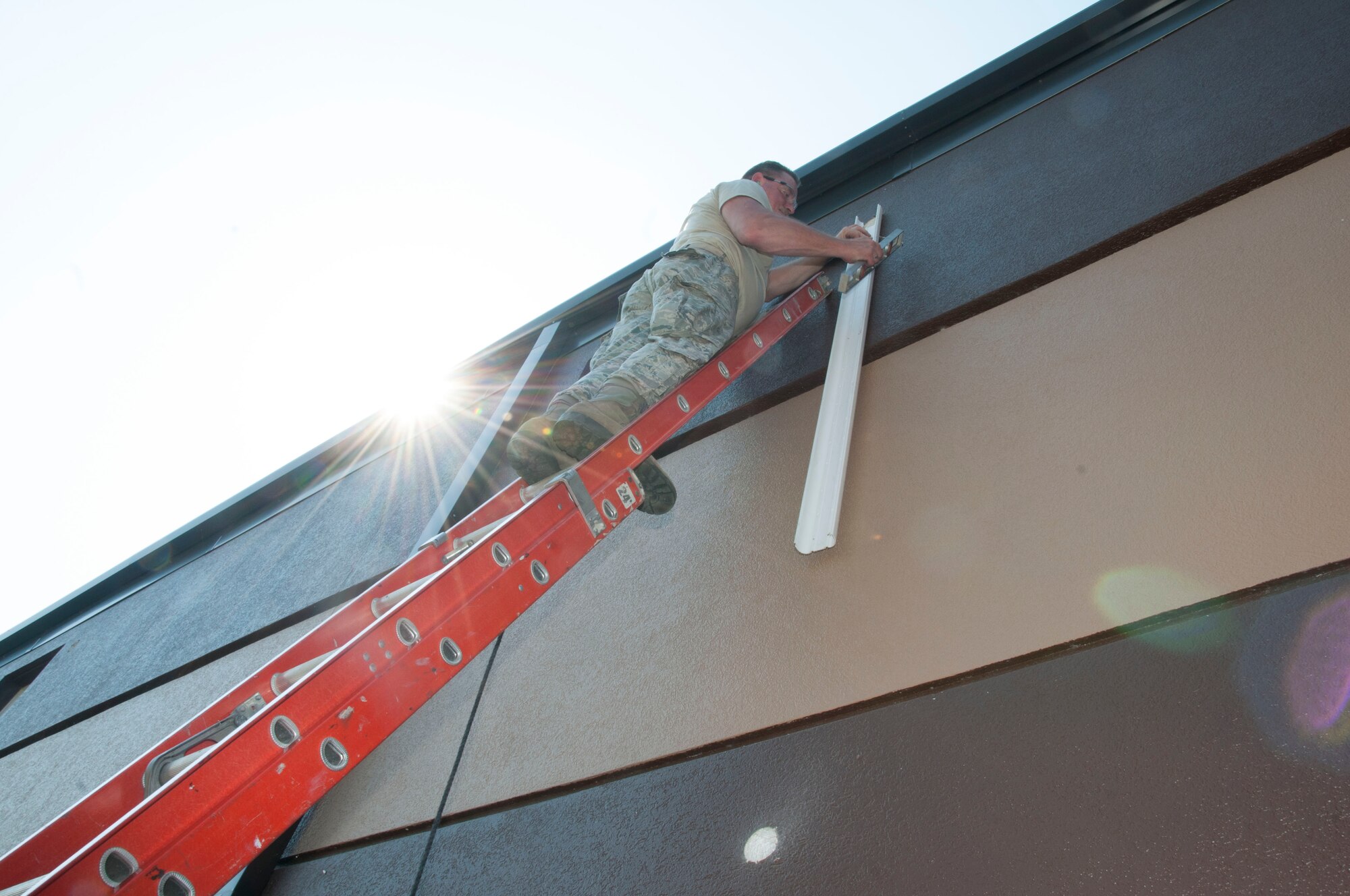 A 914th Civil Engineering Airman inspects connections in order to set up a new air conditioning and heating unit outside the 30th Aerial Port Squadron building at the Niagara Falls Air Reserve Station, N.Y. July 19. More than 20 Airmen of the 914th Civil Engineering Squadron repaired and updated installtion buildings during their two weeks of annual training here. (U.S. Air Force photo by Tech. Sgt. Joseph McKee)