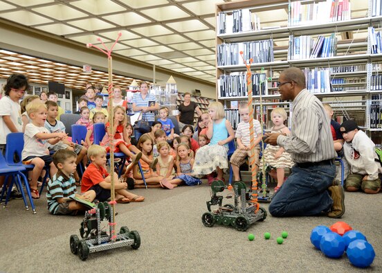 412th Test Wing Science, Technology, Engineering and Mathematics outreach director, Mickey Bowen, uses VEX Claw bots to teach children about motors during the base library’s summer reading program. (U.S. Air Force photo by Rebecca Amber) 