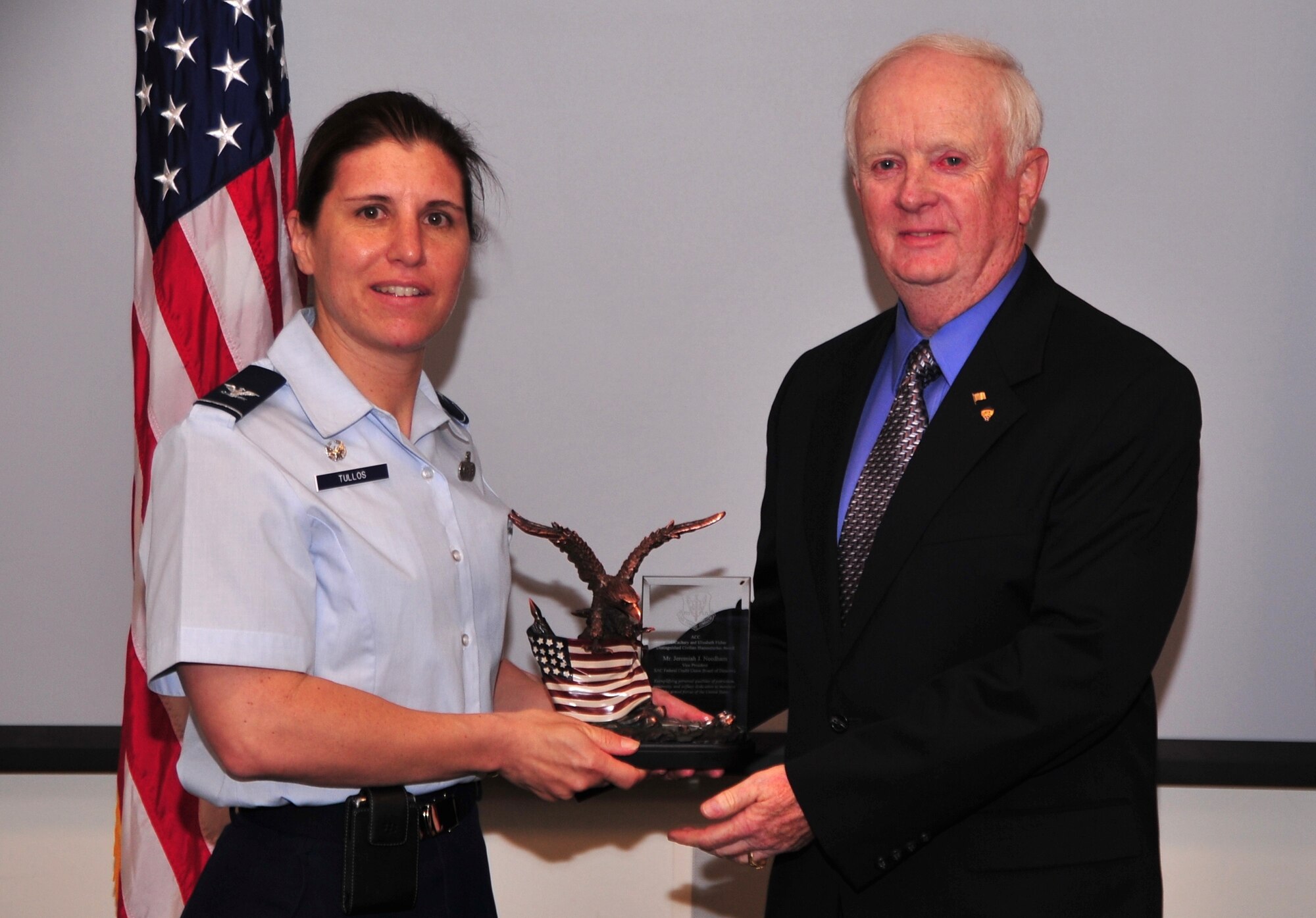 Jeremiah Needham, 55th Contracting Squadron, was presented with the prestigious Air Combat Command 2013 Zachary and Elizabeth Fisher Distinguished Civilian Humanitarian Award plaque by U.S. Air Force Col. Andrea Tullos, former 55th Mission Support Group commander, June 19. The award was given to him for his distinguishing work on humanitarian and community service projects in the community.  (U.S. Air Force Photo by D.P. Heard/Released)
