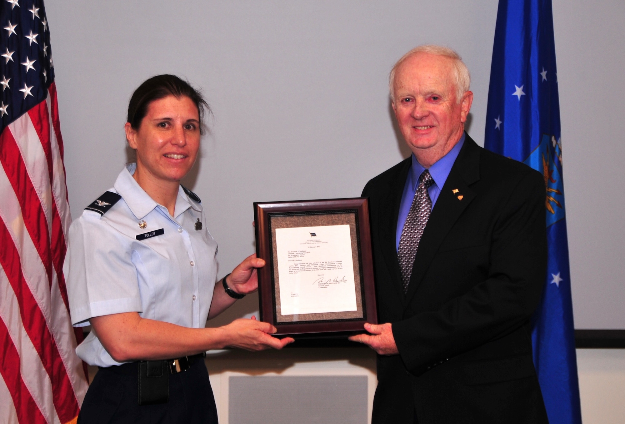 Jeremiah Needham, 55th Contracting Squadron, was presented with the prestigious Air Combat Command 2013 Zachary and Elizabeth Fisher Distinguished Civilian Humanitarian Award by U.S. Air Force Col. Andrea Tullos, former 55th Mission Support Group commander, June 19. The award was given to him for his distinguishing work on humanitarian and community service projects in the community. (U.S. Air Force photo by D.P. Heard/Released)