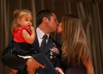Staff Sgt. Dale C. Young from the 342nd Training Squadron holds his daughter Karina as he kisses his wife Rayna Young (cq) after being awarded a Silver Star during a ceremony at Joint Base San Antonio-Lackland on Monday July 22, 2013. Air Force Special Operations Command Lt. General Eric Fiel presented the commendations.(Photo By Helen L. Montoya/San Antonio Express-News)