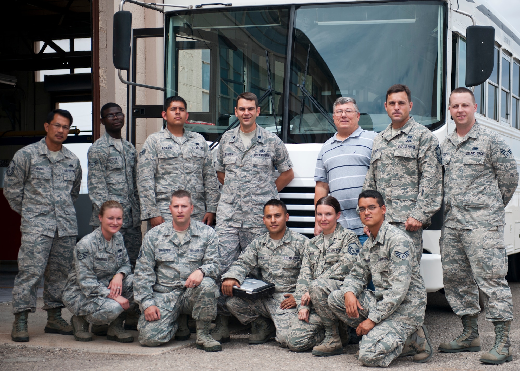 Lieutenant Colonel Robert Bearden, 49th Logistics Readiness Squadron commander, and the 49th Logistics Readiness Squadron vehicle maintenance unit stand in front of a bus in their fleet at Holloman Air Force Base, N.M., July 19. Vehicle maintenance was instrumental in the squadron in achieving the Green Fleet Certification. A culmination of efforts, including data pull and vehicle adjustments, led to lower emissions throughout the fleet. (U.S. Air Force photo by Airman 1st Class Daniel E. Liddicoet/Released)