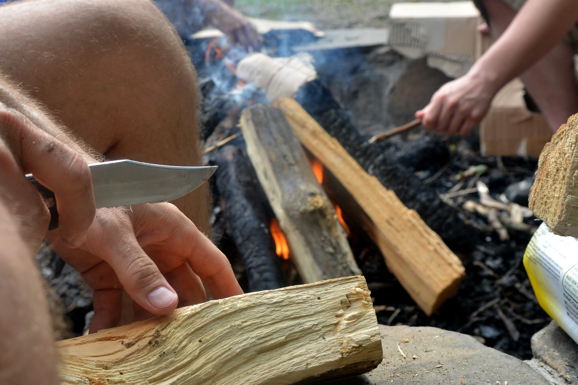 U.S. Air Force 1st Lt. Douglas Dixon, 20th Fighter Wing chaplain reservist, cuts pieces of wood to start a camp fire during a whitewater rafting trip, Bryson City, N.C., July 21, 2013. The Shaw Air Force Base chapel sponsored the out-of-town opportunity for Team Shaw single service members to focus on resiliency, physical challenge and social growth.. (U.S. Air Force photo by Airman 1st Class Ashley L. Gardner/Released)