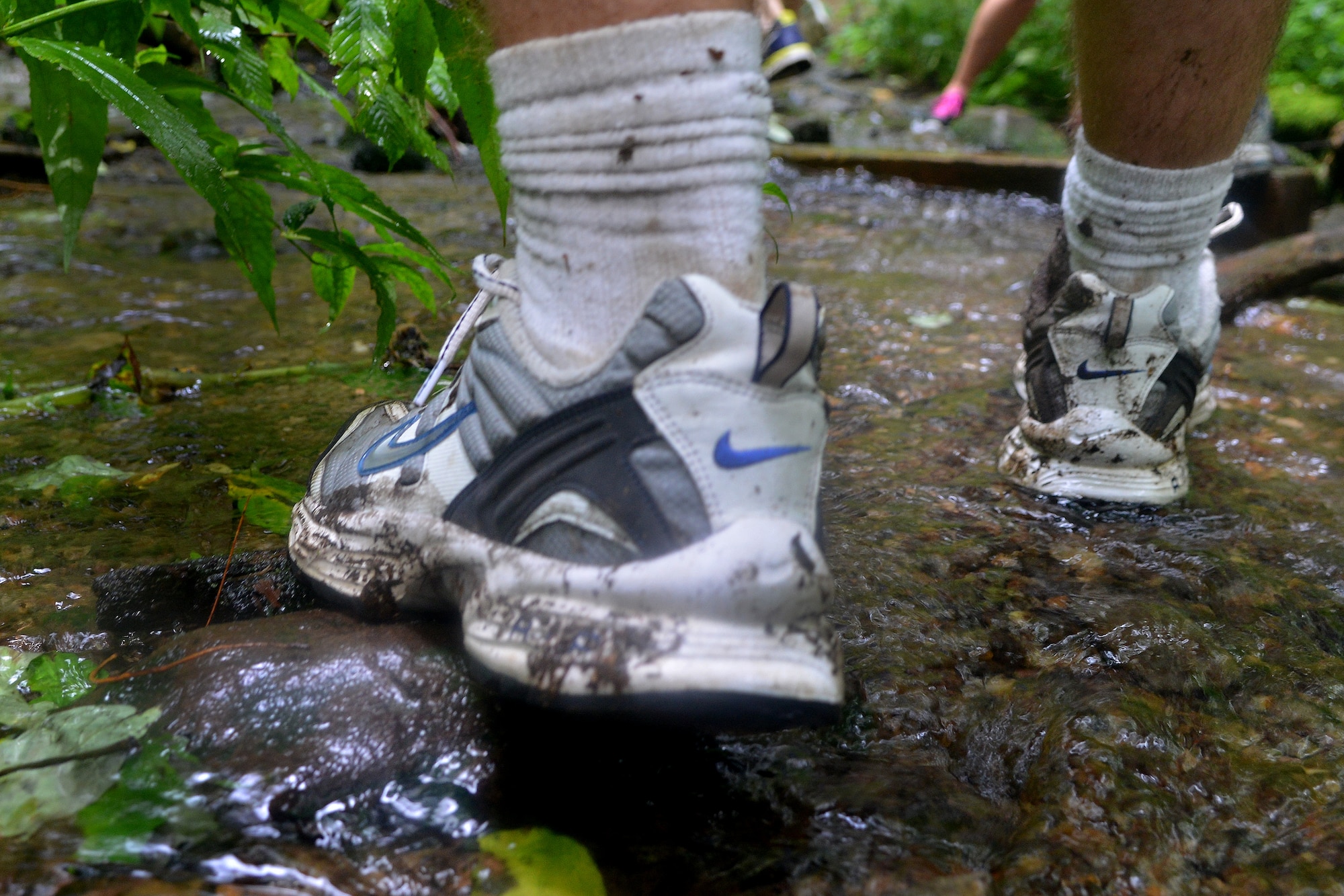 An Airman gets his shoes muddy while trying to avoid water during a two- mile hike in Bryson City, N.C., July 21, 2013. The Shaw Air Force Base chapel sponsored the out-of-town opportunity for Team Shaw single service members to focus on resiliency, physical challenge and social growth.. (U.S. Air Force photo by Airman 1st Class Ashley L. Gardner/Released)