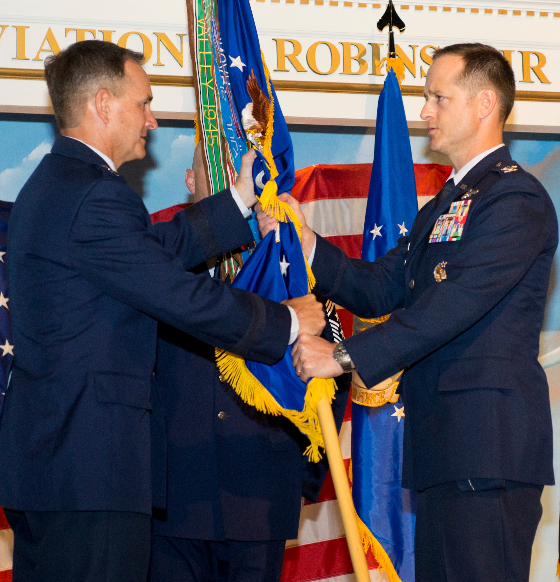 Maj. Gen. Jake Polumbo, left, Commander, 9th Air Force, hands the 461st Air Control Wing guidon to Col. Henry Cyr during a change of command ceremony at the Century of Flight Hangar, Museum of Aviation, Warner Robins, Ga., July 23, 2013. During the ceremony, Col. L. Dean Worley relinquished command of the 461st ACW to Cyr who takes over after serving as vice commander of the wing for the past two years. (U.S. Air National Guard photo by Master Sgt. Roger Parsons/Released)

