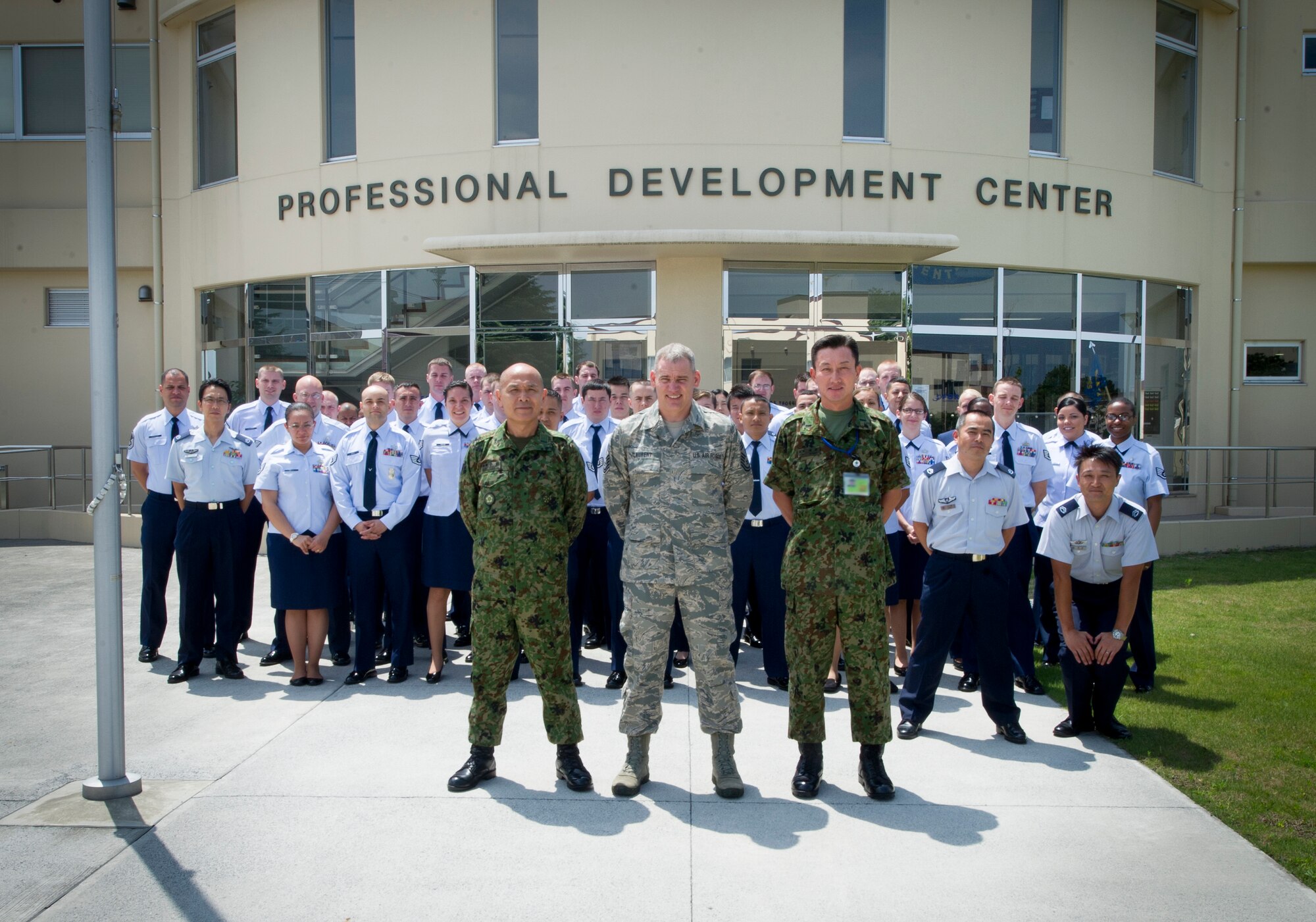 YOKOTA AIR BASE, Japan -- Japan Ground Self-Defense Force Warrant Officer Yoshihiro Obata, Japan Joint Staff Office senior enlisted advisor; and United States Forces, Japan and 5th Air Force Command Chief Master Sgt. James Laurent stand with Airmen for a group photo July 22, 2013, at Yokota Air Base, Japan. Obata and Laurent observed a conflict management briefing at the Yokota's Professional Development Center. (U.S. Air Force photo by Staff Sgt. Stacy Moless)