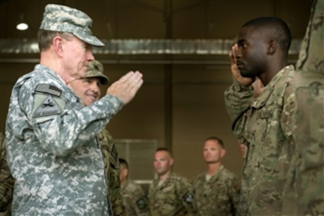 Chairman of the Joint Chiefs of Staff Gen. Martin E. Dempsey returns an airman’s salute as he meets the airmen assigned to the support the air-refueling mission at Mazar-e-Sharif, Afghanistan, on July 21, 2013.  Dempsey is in Afghanistan to meet Afghan senior leaders, NATO members, U.S. leadership and U.S. troops deployed there.  