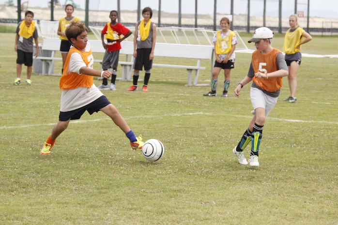 Sam Valdez, left, and Danielle Piper, both Seahorse Soccer Camp participants, practice passing drills during a scrimmage match before their final game during the Seahorse Soccer Camp held at Penny Lake Field at Marine Corps Air Station Iwakuni, Japan, July 18, 2013. The Southern California Seahorse is celebrating its 30th anniversary since its founding in 1983.