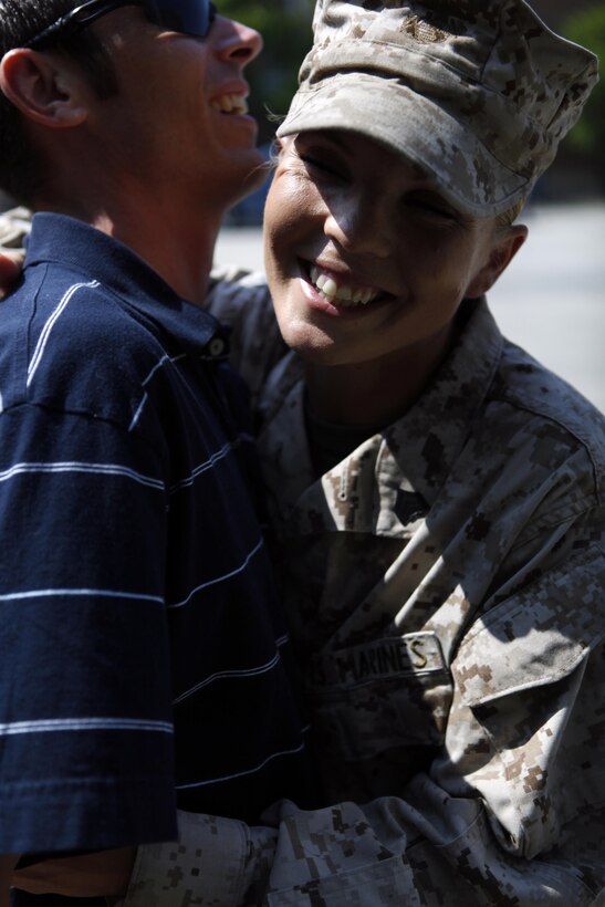 Sgt. Kirby D. Kuhn, a combat instructor with School of Infantry - East, Combat Training Battalion, Company F., hugs her husband, Ronald Kuhn, after receiving a Navy and Marine Corps Achievement during an awards ceremony aboard Camp Geiger, June 17. Kuhn helped save one of her Marine student’s lives’ by helping to clear the student's airway and applied cardiopulmonary resuscitation until emergency services arrived during a M203 grenade launcher practical application exam, May 26.