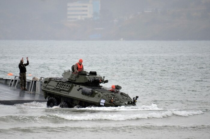 Pohang, South Korea - Staff Sgt. Todd J. Piluk, center, and Cpl. Charles H. Parmley, right, drive a light armored vehicle to shore during a maritime prepositioning force off-load April 20 at Dogu Beach near Pohang, Republic of Korea. The Joint Integration and Transportability Branch in Marine Corps Systems Command’s Systems Engineering Interoperability Architectures and Technology office works with the Navy to ensure Marines and their systems are able to move smoothly from operations aboard Navy ships directly into operations ashore. 
