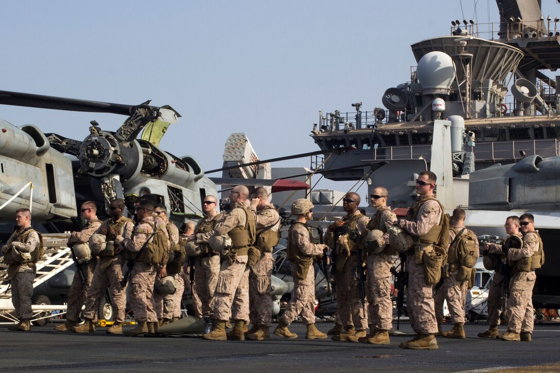 U.S. Marines assigned to Combat Logistics Battalion 26, 26th Marine Expeditionary Unit (MEU), prepare to conduct a Table 3 live-fire exercise on the flight deck of the USS Kearsarge (LHD 3), at sea, July 25, 2013. The 26th MEU is a Marine Air-Ground Task Force forward-deployed to the U.S. 5th Fleet area of responsibility aboard the Kearsarge Amphibious Ready Group serving as a sea-based, expeditionary crisis response force capable of conducting amphibious operations across the full  range of military operations. (U.S. Marine Corps photo by Cpl. Kyle N. Runnels/Released)