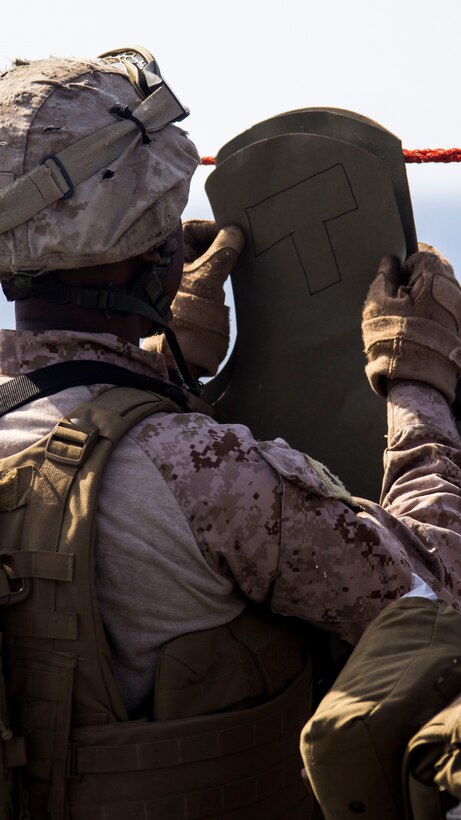 A U.S. Marine assigned to Combat Logistics Battalion 26, 26th Marine Expeditionary Unit (MEU), attaches a target before conducting a Table 3 live-fire exercise on the flight deck of the USS Kearsarge (LHD 3), at sea, July 25, 2013. The 26th MEU is a Marine Air-Ground Task Force forward-deployed to the U.S. 5th Fleet area of responsibility aboard the Kearsarge Amphibious Ready Group serving as a sea-based, expeditionary crisis response force capable of conducting amphibious operations across the full  range of military operations. (U.S. Marine Corps photo by Cpl. Kyle N. Runnels/Released)