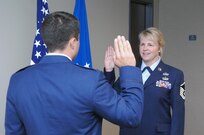 Air Force Master Sgt. Julie Stava, U.S. Northern Command J39 knowledge operations manager, receives the oath of enlistment from her son, Air Force 2nd Lt. Felix Abeyta, in a re-enlistment ceremony in USNORTHCOM headquarters July 7. Stava re-enlisted for the final time after 20 years of service. Her last re-enlistment ceremony is her son's first. Abeyta graduated from the U.S. Air Force Academy in 2010 and is currently a spacelift program manager with the 1st Air and Space Test Squadron at Vandenberg Air Force Base, Calf. He said having the opportunity to give the oath to his mother was a great honor. "She was the driving force in why I went to the academy, and she was my first salute after I graduated," he said. Upon hearing this, Stava said, "We're even now."
