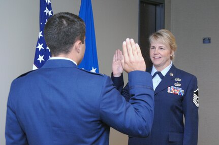 Air Force Master Sgt. Julie Stava, U.S. Northern Command J39 knowledge operations manager, receives the oath of enlistment from her son, Air Force 2nd Lt. Felix Abeyta, in a re-enlistment ceremony in USNORTHCOM headquarters July 7. Stava re-enlisted for the final time after 20 years of service. Her last re-enlistment ceremony is her son's first. Abeyta graduated from the U.S. Air Force Academy in 2010 and is currently a spacelift program manager with the 1st Air and Space Test Squadron at Vandenberg Air Force Base, Calf. He said having the opportunity to give the oath to his mother was a great honor. "She was the driving force in why I went to the academy, and she was my first salute after I graduated," he said. Upon hearing this, Stava said, "We're even now."
