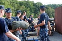 Sailors assigned to Naval Submarine Base New London place sandbags along the waterfront in preparation for possible effects from Hurricane Irene. 