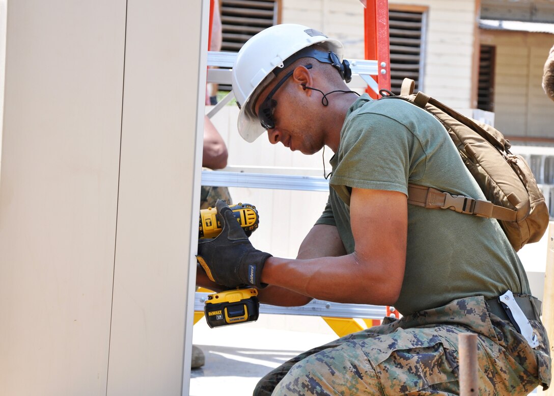 U.S. Marine Corps Sgt. Lewis Smith, a combat engineer from Marine Wing Support Squadron 471, ties reinforcing bar to support vertical reinforcement of the walls at Crooked Tree Government Primary School.  Engineers from both the U.S. and Belize are constructing various structures at schools throughout Belize as part of exercise New Horizons. (U.S. Air Force photo by Capt. Holly Hess/Released)