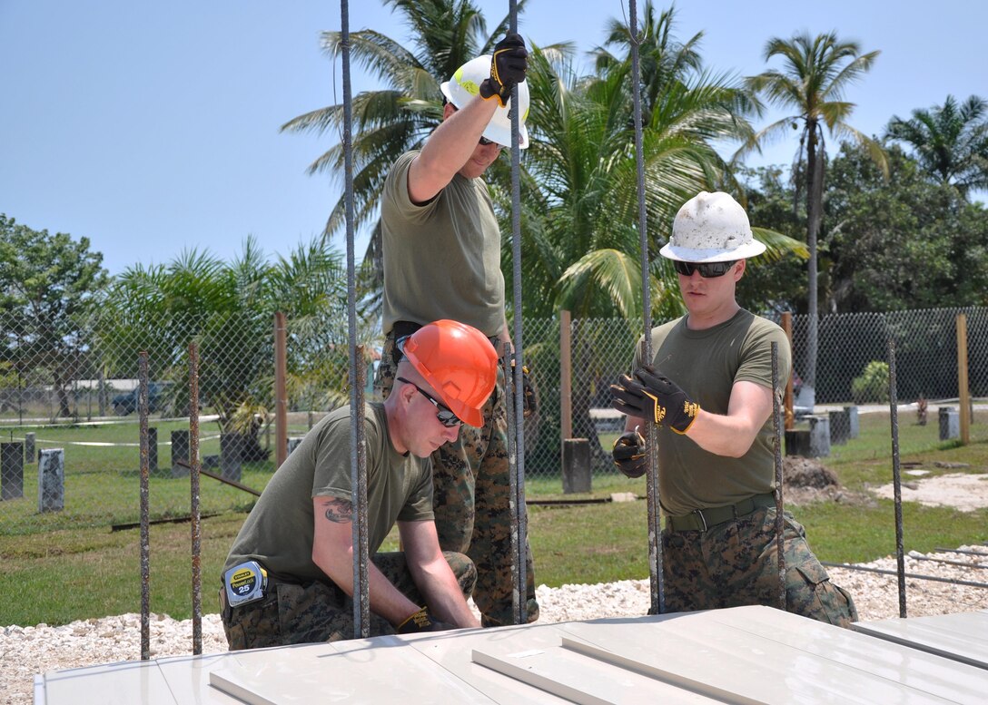 LADYVILLE, Belize— U.S. Marine Corps Pfc. Timothy Kean (left) Gunnery Sgt. Daniel Ward (center), and Sgt. Kyle Dugas, all combat engineers from Marine Wing Support Squadron 472, tie reinforcing bar to support vertical reinforcement of the walls at the construction site of Ladyville Technical High School.  Engineers from both the U.S. and Belize are constructing various structures at schools throughout Belize as part of exercise New Horizons. (U.S. Air Force photo by Capt. Holly Hess/Released)